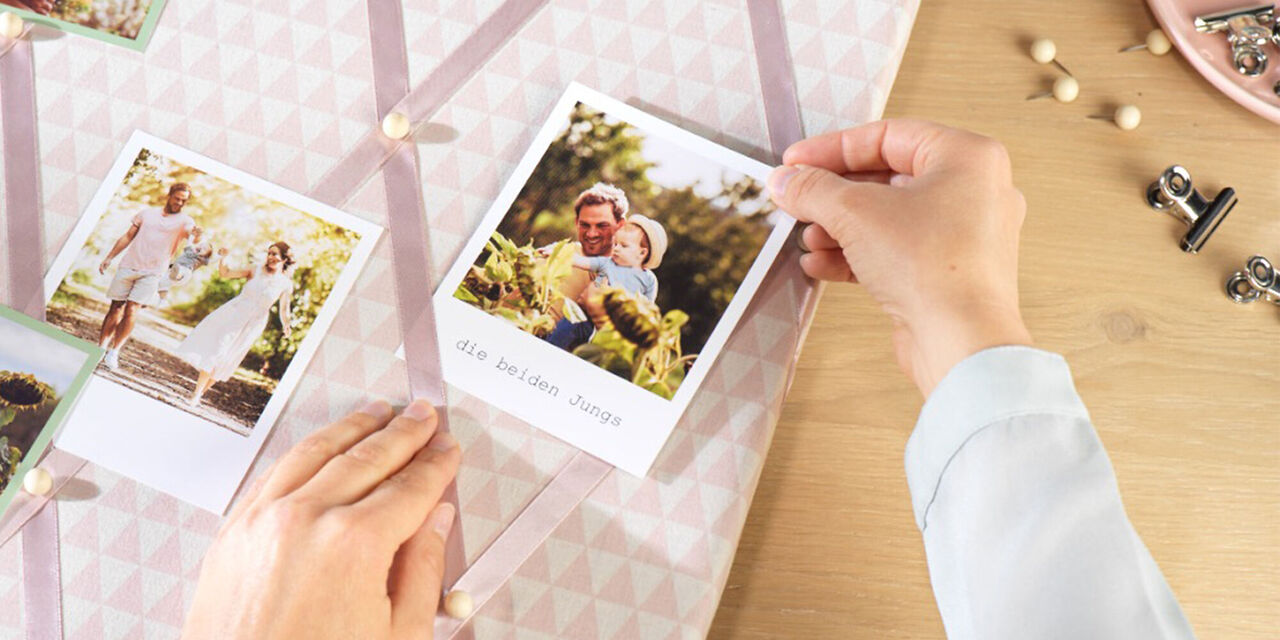 Hände stecken Familienfoto an Memo-Board.