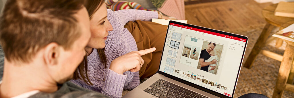 Frau und Mann bei der CEWE FOTOBUCH Gestaltung am Laptop